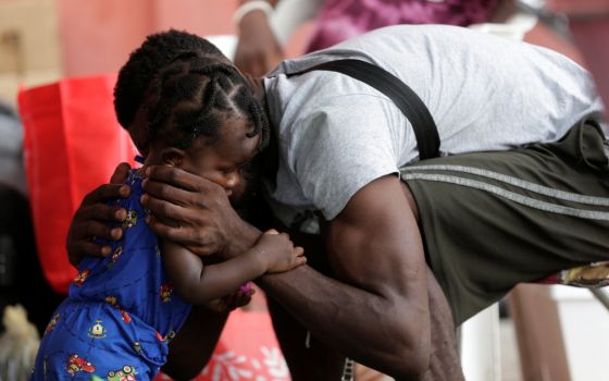 A Haitian migrant seeking refuge in the U.S., hugs his daughter outside a shelter in Monterrey, Mexico, Sept. 28, 2021. (CNS photo/Daniel Becerril, Reuters)