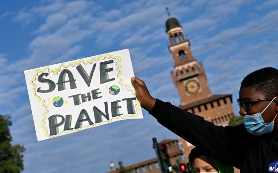 A demonstrator holds up a sign as he attends a Fridays for Future climate strike Oct. 1 in Milan (CNS/Reuters/Flavio Lo Scalzo)