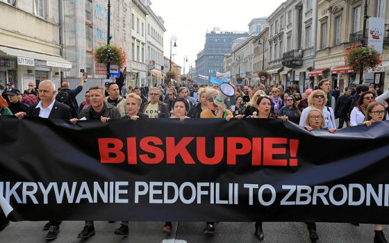 People take part during a demonstration against pedophilia, "Hands away from children," in Warsaw, Poland, Oct. 7, 2018. The banner reads, "Bishop, hiding pedophilia is a crime." (CNS/Agencja Gazeta via Reuters/Jacek Marczewski)