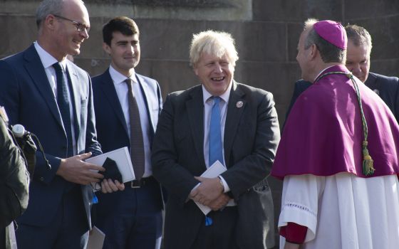 Archbishop Eamon Martin of Armagh, Northern Ireland, speaks with Irish Foreign Affairs Minister Simon Coveney, far left, and British Prime Minister Boris Johnson following a service to mark the centenary of the partition of Ireland in Armagh Oct. 21, 2021