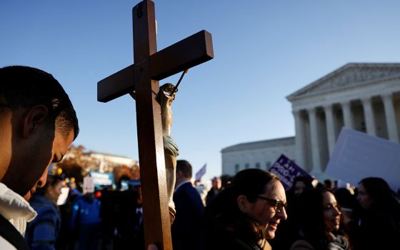 A pro-life activist holding a crucifix joins a protest outside the U.S. Supreme Court building Dec. 1, 2021, in Washington. (CNS/Reuters/Jonathan Ernst)