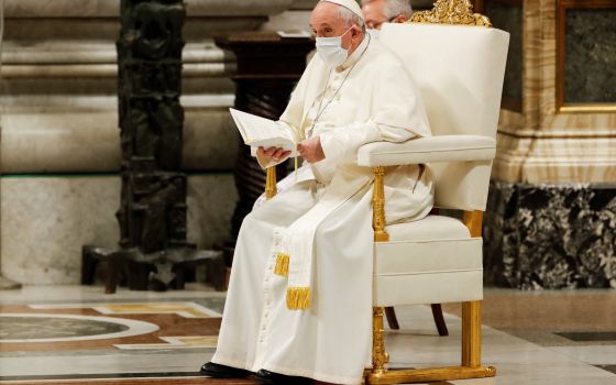 Pope Francis wears a mask for protection from COVID-19 as he participates in an evening prayer service in St. Peter's Basilica at the Vatican Dec. 31, 2021. (CNS photo/Remo Casilli, Reuters)