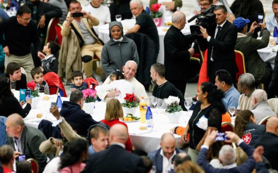 A little girl hugs Pope Francis, as he joins some 1,300 guests for lunch in the Vatican audience hall on the World Day of the Poor Nov. 13, 2022.