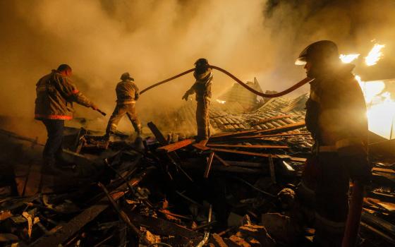 Firefighters work to extinguish fire amid debris of a residential building destroyed in shelling in Donetsk, Russian-controlled Ukraine, Dec. 9. (CNS/Reuters/Alexander Ermochenko)