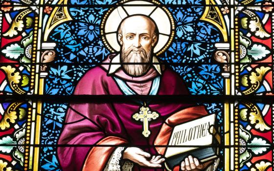 A stained glass window of a white, male, bearded saint