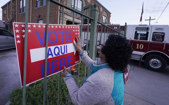 Election worker Ramona Ortiz places a sign outside a polling station at a fire station in El Paso, Texas, just before polls open on Nov. 8, 2022. (AP/LM Otero, File)