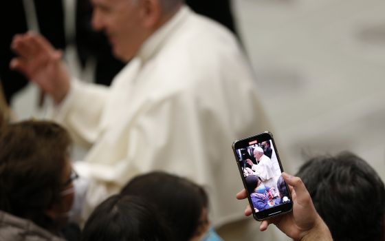 Pope Francis is pictured on a smart phone as he greets people during his general audience in the Paul VI hall at the Vatican Jan. 19, 2022. (CNS photo/Paul Haring)