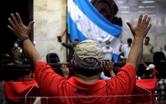 Supporters of Honduran President-elect Xiomara Castro pray inside the National Congress after the installation of the new Congress in Tegucigalpa Jan. 25, 2022. (CNS photo/Fredy Rodriguez, Reuters)