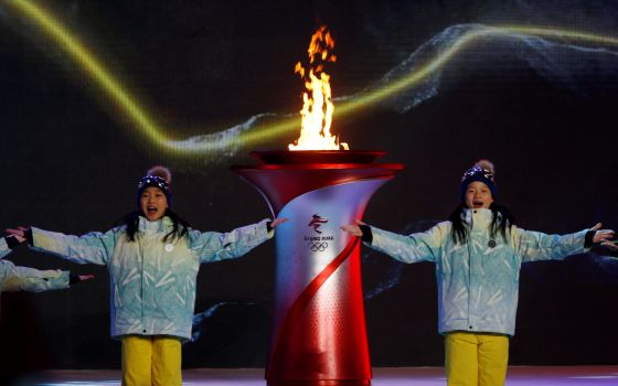 Actors perform next to a cauldron with the Olympic flame during a performance at the end of the torch relay session ahead of the Beijing 2022 Winter Olympics Feb. 2, 2022. (CNS photo/Florence Lo, Reuters)