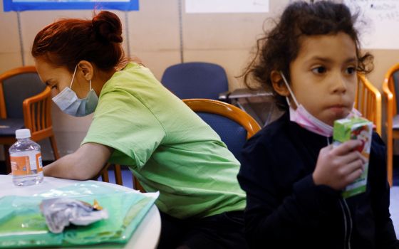 A mother and daughter from Honduras wait at La Colaborativa in Chelsea, Mass., Sept. 30, 2021, while getting help with free clothes and food as well as advice for their upcoming immigration hearing. (CNS photo/Brian Snyder, Reuters)