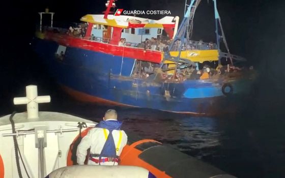 Migrants wait to be rescued by Italian coast guard during a search and rescue operation off the coast of Italy, Feb. 22, 2022, in this screen grab taken from a handout video. (CNS photo/Italian Coast Guard/handout via Reuters)