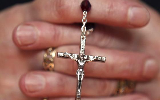 A woman holds a rosary during a March 21, 2010, Mass at a church in Armagh, Northern Ireland. (CNS/Reuters/Cathal McNaughton)