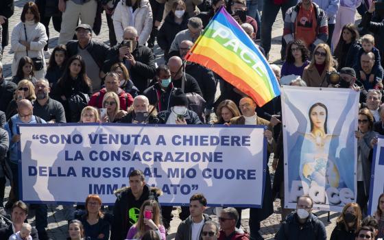 People in St. Peter's Square hold an image of Mary and peace flags during Pope Francis' recitation of the Angelus at the Vatican March 13, 2022. (CNS photo/Vatican Media)