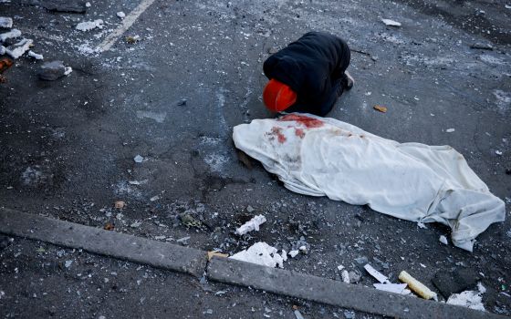 A man in Kyiv, Ukraine, mourns his mother, who was killed when an intercepted missile hit a residential building March 17, 2022. (CNS photo/Thomas Peter, Reuters)