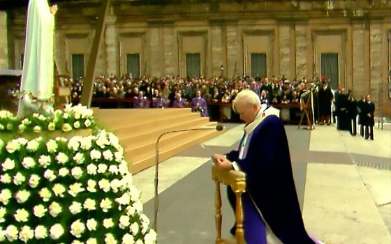 Pope John Paul II kneels in front of the statue of Our Lady of Fatima as he entrusts "all men and women and all peoples to the Immaculate Heart of Mary," in St. Peter's Square at the Vatican in this March 25, 1984, photo. (CNS photo/Vatican Media)