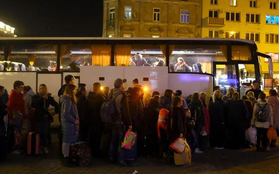 Ukrainian refugees in Przemysl, Poland, wait to board a bus to take them to a temporary shelter March 23, after fleeing the Russian invasion. (CNS/Reuters/Hannah McKay)