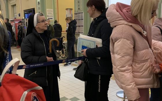 Sr. Lucja Kwasniak, a member of the Sisters, Servants of the Immaculate Heart of Mary, talks to Ukrainian refugees April 21 at the train station in Przemysl, Poland.