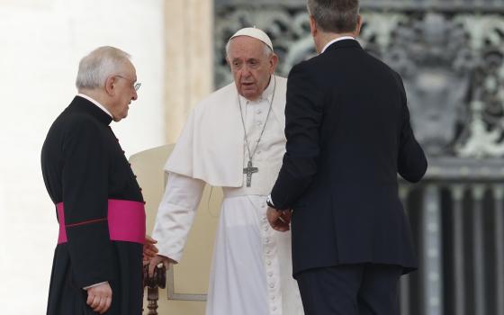 Pope Francis is assisted by his aide, Sandro Mariotti, right, and Msgr. Leonardo Sapienza, an official of the prefecture of the Papal Household, as he gets up from his chair during his general audience May 4 in St. Peter's Square at the Vatican. (CNS/Paul