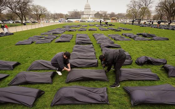 Body bags are placed on the National Mall in Washington near the U.S. Capitol on March 24. (CNS/Reuters/Kevin Lamarque)