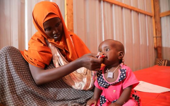 A displaced Somali woman feeds her child in a shelter during a severe drought near Dollow May 26. (CNS/Reuters/Feisal Omar)