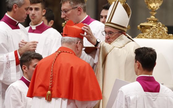 Pope Francis places a red biretta on new U.S. Cardinal Kevin Farrell during a consistory in St. Peter's Basilica at the Vatican in this Nov. 19, 2016, file photo. (CNS/Paul Haring)