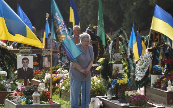 A woman mourns as she visits the tomb of her relative on Independence Day in Lviv, Ukraine, Aug. 24, 2022.