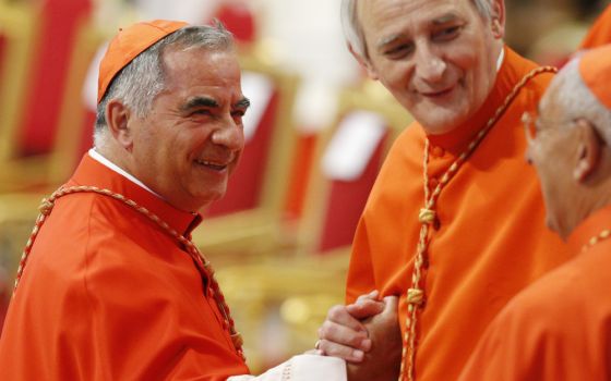 Cardinal Angelo Becciu, left, greets Cardinal Matteo Zuppi of Bologna as he arrives for a consistory led by Pope Francis for the creation of 20 new cardinals in St. Peter's Basilica at the Vatican Aug. 27, 2022. (CNS photo/Paul Haring)