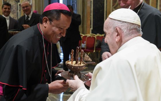 Pope Francis accepts a gift during an audience with almost 200 new bishops participating in a formation course