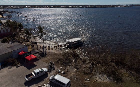 The U.S. Coast Guard in Matlacha, Fla., loads water and other supplies on a boat to be delivered to Pine Island Oct. 2, 2022, after Hurricane Ian caused widespread destruction. (CNS photo/Marco Bello, Reuters)