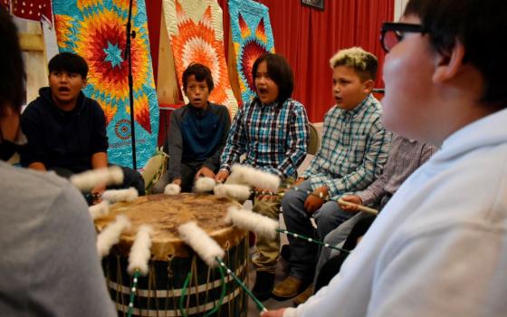 Students from Rosebud Elementary School perform in a drum circle during a meeting about abusive conditions at Native American boarding schools at Sinte Gleska University on the Rosebud Sioux Reservation in Mission, S.D.