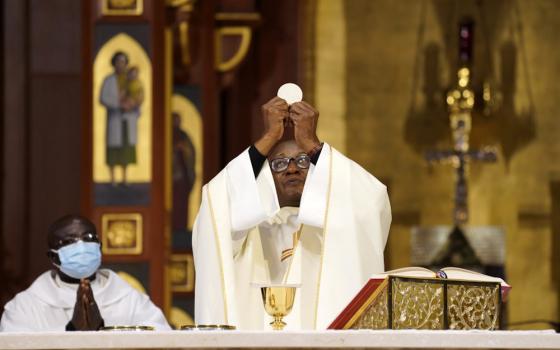 Fr. Eden Jean Baptiste elevates the Eucharist as he celebrates a Mass for Catholics of Haitian ancestry at St. Agnes Cathedral in Rockville Centre, New York, Jan. 1, 2022, the feast of Mary, Mother of God. (CNS/Gregory A. Shemitz)