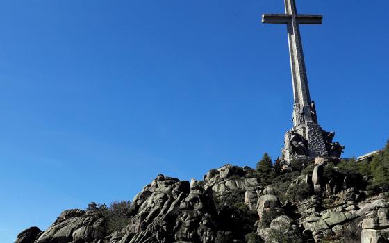 A helicopter carrying the coffin of former Spanish dictator Gen. Francisco Franco flies above the mausoleum where the tomb of former Spanish dictator was located in the Valley of the Fallen near Madrid before it was exhumed Oct. 24, 2019. (CNS photo/Emilio Naranjo, pool via Reuters) 