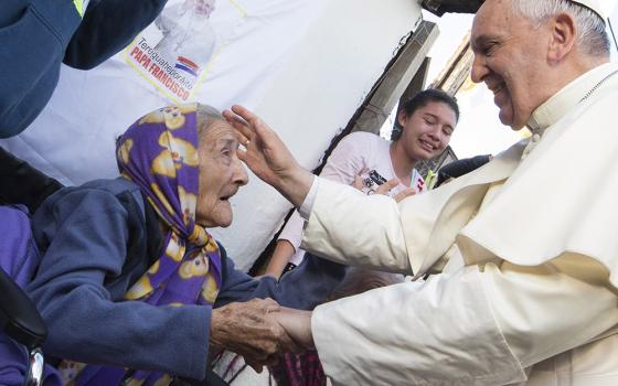 Pope Francis greets an elderly woman as he meets with people in a poor neighborhood in Asuncion, Paraguay, in this July 12, 2015, file photo. (CNS/Paul Haring)