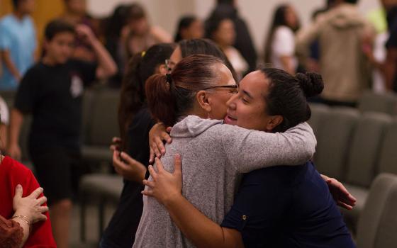 Two people hugging among other people greeting each other (Unsplash/Erika Giraud)