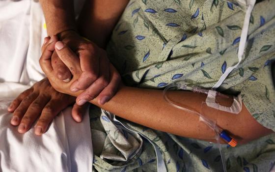 A hospital patient is comforted by a family member in this illustration photo. The U.S. Catholic bishops issued a document dated March 20 rejecting gender-affirming medical treatments for transgender individuals and reasserting that such procedures must not be performed by Catholic providers. (CNS/Reuters/Caitlin O'Hara)