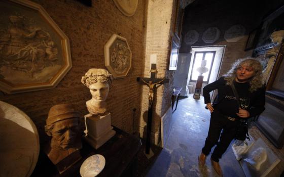 A woman stands in a dim stone hall with Roman stone sculptures