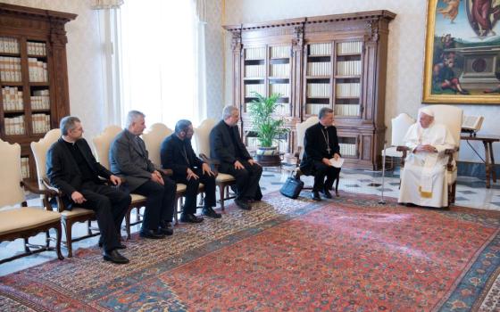 Pope Francis meets with members of the preparatory commission for the general assembly of the Synod of Bishops in the library of the Apostolic Palace at the Vatican March 16, 2023. Pictured to the left of the pope are: Cardinal Mario Grech, secretary-general of the Synod; Jesuit Father Giacomo Costa, commission coordinator; Bishop Daniel E. Flores of Brownsville, Texas; Father Dario Vitali; and Msgr. Tomasz Trafny. (CNS photo/Vatican Media)