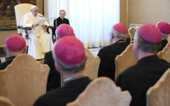 A sea of men in violet zucchettos sits in front of Pope Francis and a man in a black cassock with not zucchetto