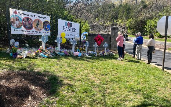 People pay respects at a memorial for the six people who were killed by a shooter, at an entry to The Covenant School in Nashville, Tennessee