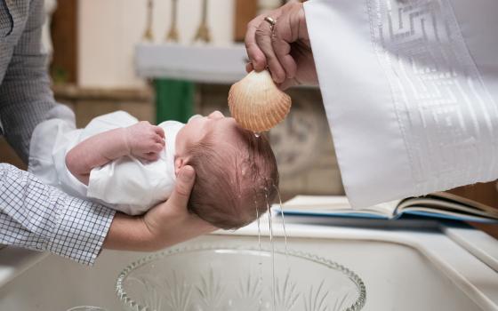 An infant being baptized. (Unsplash/Josh Applegate)