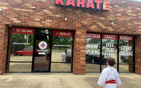 The author's son stands in front of the dojo that has become a haven of love and belonging — a sacred space — for their family. (Courtesy of Britt Luby)