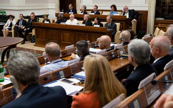 Pope Francis speaks June 14, 2019, to executives of leading energy companies meeting at the Vatican to discuss mitigating the effects of climate change. The pope is seated between Cardinal Peter Turkson, then-president of the Dicastery for Promoting Integral Human Development, and Holy Cross Fr. John Jenkins, president of the University of Notre Dame, co-sponsors of the meeting. (CNS photo/Vatican Media)