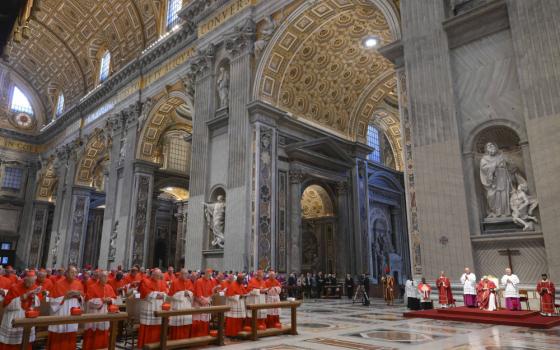 Many men dressed in red and white sit beneath the towering domed ceilings of a cathedral