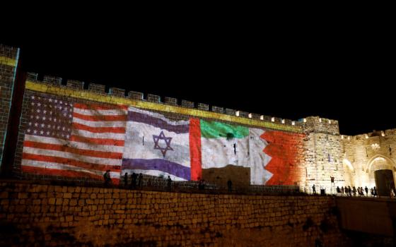 The flags of the United States, Israel, United Arab Emirates and Bahrain are projected on a section of the walls surrounding Jerusalem's Old City Sept. 15, 2020, as United Arab Emirates and Bahrain sign agreements toward normalizing relations with Israel at a White House ceremony in Washington. (CNS/Reuters/Ronen Zvulun)