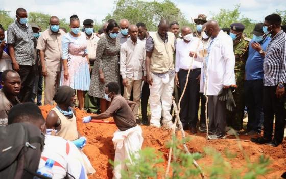 Kenyan authorities retrieve bodies from shallow graves April 27  on an 800-acre ranch in Kilifi County. 