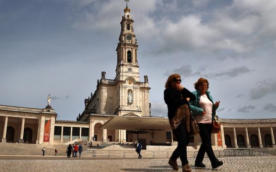 Women walk at the Marian shrine of Fátima in central Portugal March 30. (OSV News/Reuters/Pedro Nunes)