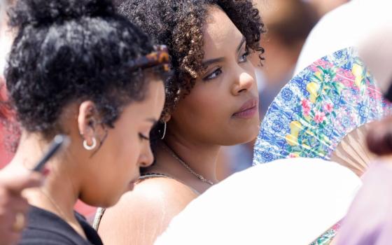 Women fan themselves to cool off from the heat as visitors wait to pray the Angelus with Pope Francis in St. Peter's Square at the Vatican July 16, 2023. (CNS/Lola Gomez)