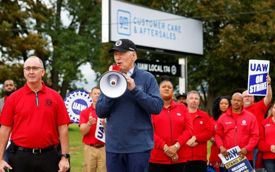 U.S. President Joe Biden speaks next to Shawn Fain, president of the United Auto Workers, as he joins striking UAW members on the picket line outside the GM's Willow Run Distribution Center in Belleville, Michigan, Sept. 26. Biden became the first known sitting U.S. president to join a labor strike. (OSV News/Reuters/Evelyn Hockstein)