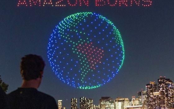 People watch drones creating a 3D display outside the United Nations Headquarters calling attention to the Amazon rainforest and climate change in New York City Sept. 15. (OSV News/Reuters/Eduardo Munoz)