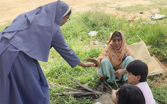 Poor Handmaids of Jesus Christ Sr. Bindu Jose at the garbage dumping yard in Bellahalli tries to recruit students to her early learning center at the outskirts of Bengaluru in southern India. (GSR photo/Thomas Scaria)